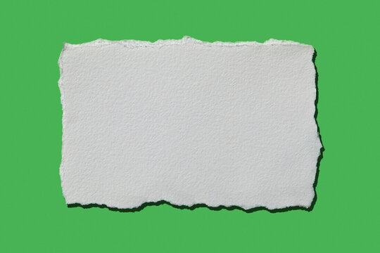 White torn paper on green background