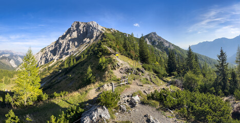 Fototapeta premium Scenic view of mountain peak Hochturm in Hochschwab region, Styria, Austria. Steep rocky cliffs covered in deciduous trees in vibrant autumn colors. Wanderlust Austrian Alps.