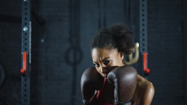 Cinematic video of a fit young woman training in the gym with weights and aerobic exercises. Boxer Woman doing shadow boxing workoutin the fitness club.