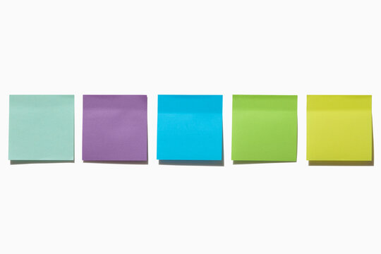 Row of blank colorful post it notes on white background