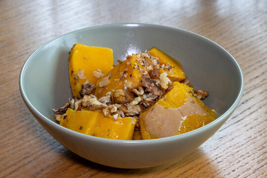 Oven-roasted pumpkin drizzled with olive oil and sprinkled with chopped walnuts.