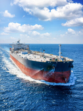 Aerial view of a crude oil super tanker ship traveling with speed over the ocean as a transport concept for fossil fuel