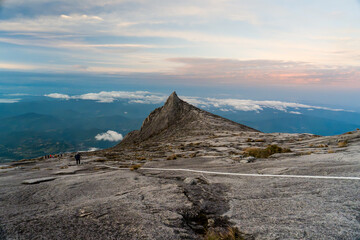 Lone hiker stands on a rocky peak © jinhongljh