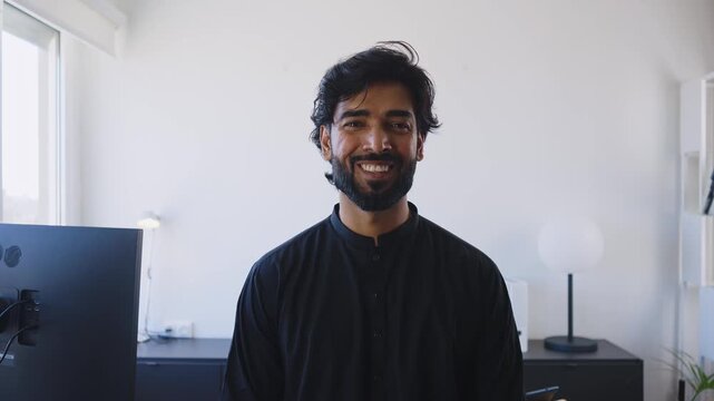 Pakistani Business man in the office. Corporate scene in a modern office with a businessman from pakistan in traditional jubba kandora.