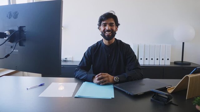 Pakistani Business man in the office. Corporate scene in a modern office with a businessman from pakistan in traditional jubba kandora.