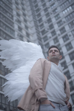 Guardian angel man looking away by modern skyscraper block with text space