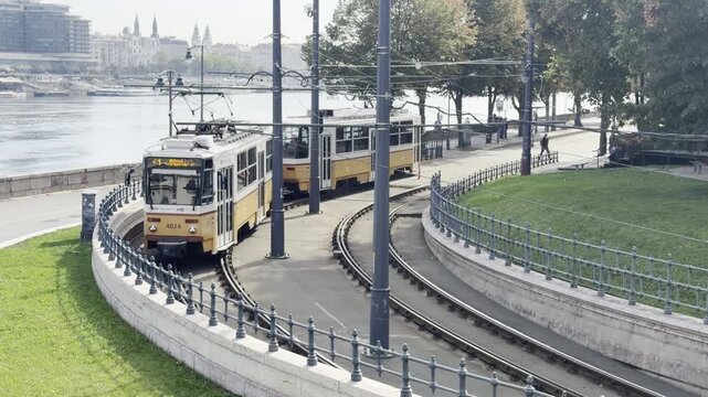 Two trams with the Danube and Budapest in the background