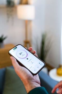 Smartphone showing room temperature control app in living room