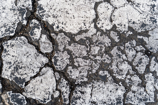 Cracked asphalt pavement with weathered surface texture outdoors