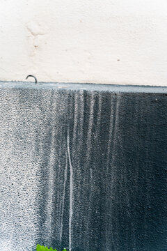 Exterior wall with weathered black and white textured paint