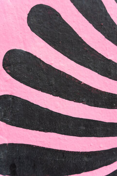 Abstract black pattern painted on pink textured wall