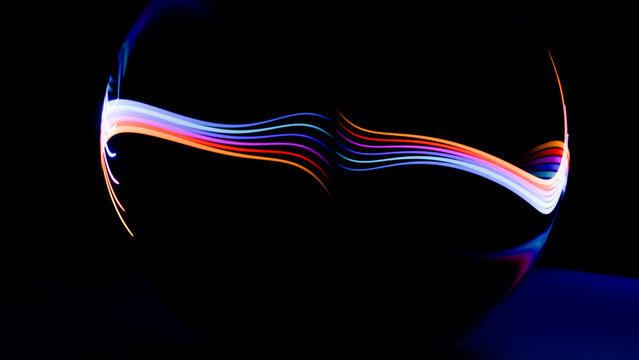 Curved colorful light trails against dark background abstract art
