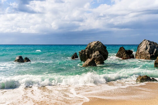 Dramatic seascape on golden sand coast with clouds during morning or evening. Dramatic day over the sea with blue clouds and turquiose sea surf