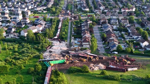 Aerial view of excavation machinery and disturbed ground beside rows of homes and green vegetation in Repentigny Quebec Canada