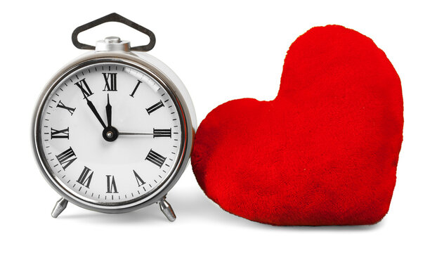 Clock and red heart on white background showing time and symbol of love