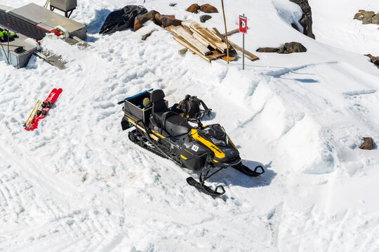 Snowmobile parked on a snowy slope beside skis and maintenance equipment at Whakapapa Ski Field in New Zealand