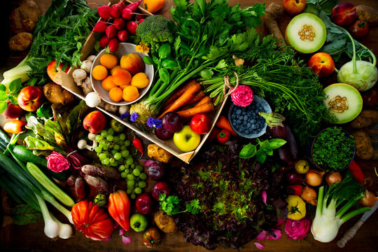 Arrangement of fresh summer fruits and vegetables on wooden table