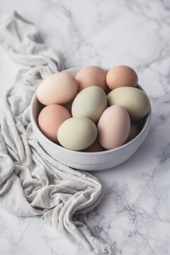 Raw eggs in a bowl, on a marble surface