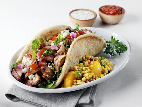 Mediterranean chicken shawarma with folded pita and couscous salad