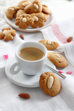 Almond cookies with coffee in a white cup and saucer