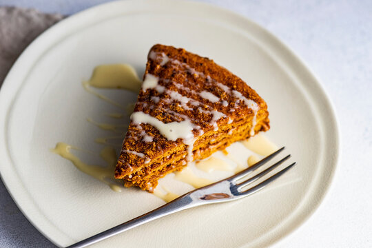 Honey cake slice drizzled and served on a plate