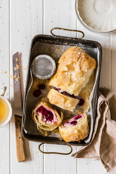 Cherry and ricotta strudel sliced in a baking dish with powdered sugar