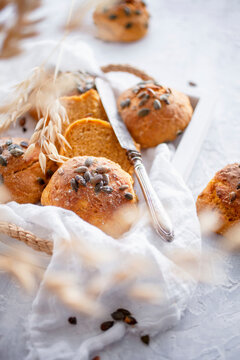 Carrot bread rolls topped with pumpkin seeds on tray