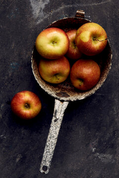 Braeburn apples in enamel colander with moisture droplets