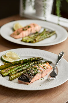 Freshly grilled salmon fillet with asparagus and lemon wedges