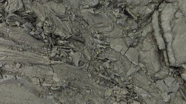 Aerial drone push in shot, top down view of a unique cracked volcanic earth texture on Iceland. This barren lava field forms an abstract pattern, showcasing the rugged nature of the remote landscape.