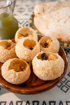 Traditional Indian panipuri golgappa snack served with mint flavored water.