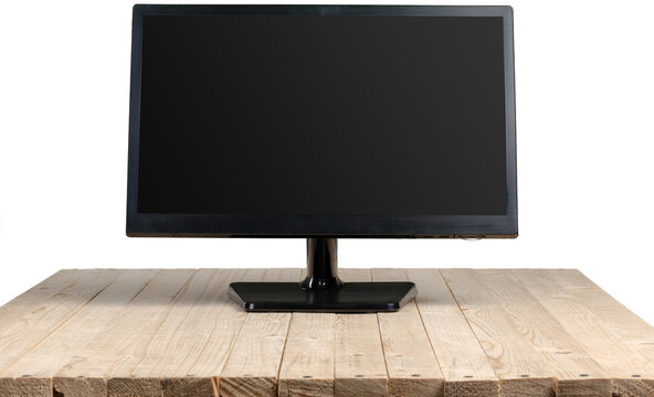 Black computer monitor on a wooden table in a simple setup