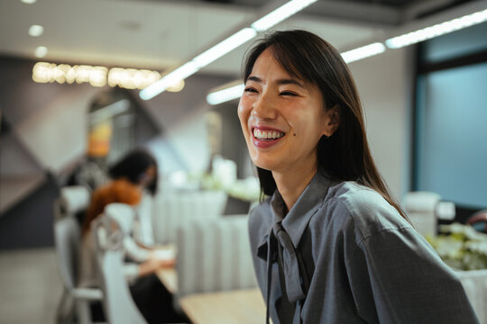 Smiling asian businesswoman enjoying a happy work environment
