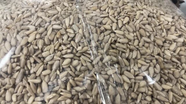 Close-up of clear plastic bags filled with hulled sunflower seeds in grosery