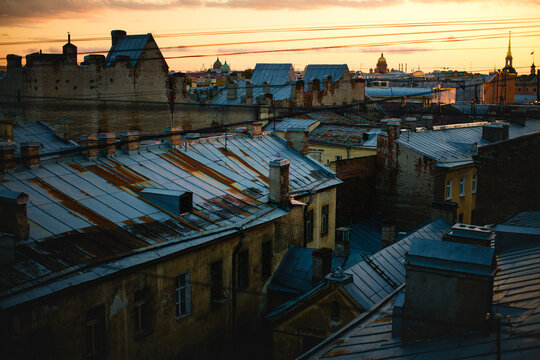 Rooftops of Saint Petersburg at sunset with historic buildings chimneys and cathedral domes on the skyline