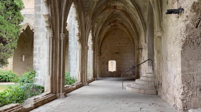 Kyrenia, Cyprus - October 3, 2026 Gothic stone arches define Bellapais Abbeys peaceful cloister, with garden greenery and raised stairway. Abbaye de la Paix is rich in medieval character.