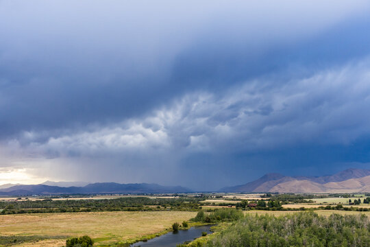 Dark storm clouds over fields and river