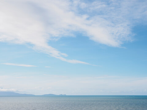White delicate clouds above calm sea