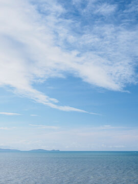 White delicate clouds above calm sea
