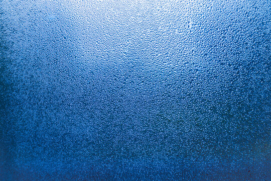 Condensation patterns on glass with cool tones