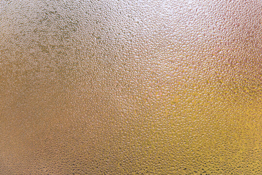 Condensation patterns on glass with warm tones