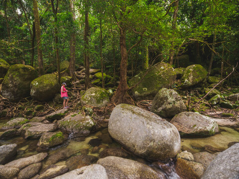 Tourist looking at phone while standing next to Mossman River