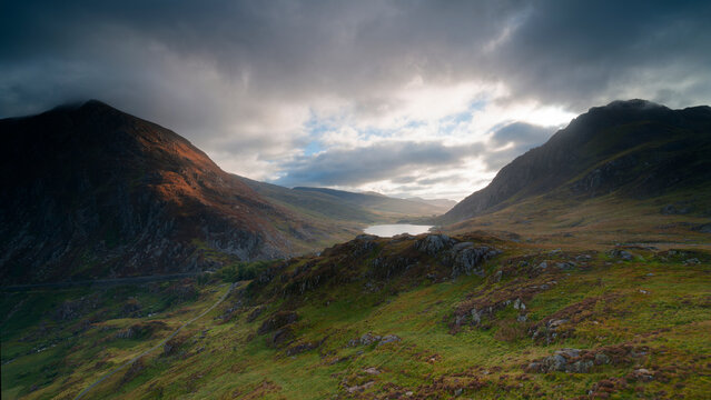 Elevated panoramic view of Llyn Ogwen lake and Tryfan mountain under dramatic storm clouds, Snowdonia, Wales