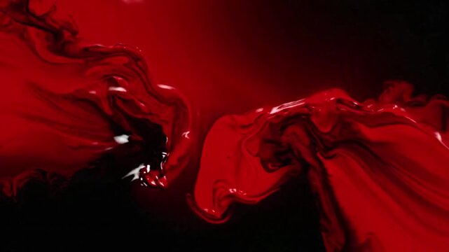 Black red gradient background, bright red liquid paint flows and blends into deep black ink creating beautiful abstract shapes and artistic patterns on a smooth dark background surface
