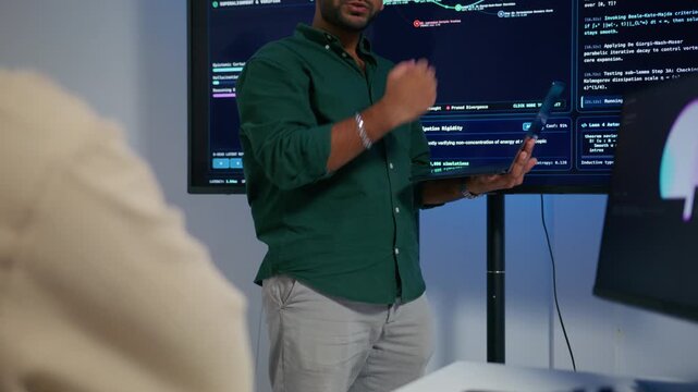 Professional Indian Software Engineer Presenting and Explaining Software Deployment Generative Artificial Intelligence Application Development to Colleagues During Professional Technical Meeting.