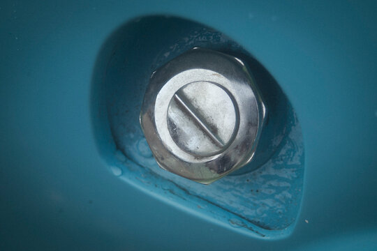 shot of a vintage blue car chrome fuel tank cap.
A high-quality close-up macro photograph focusing on the classic chrome or stainless steel gas fuel filler cap of a vintage retro automobile. 