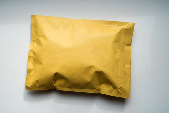 Yellow kraft padded bubble mailer envelope on white background for e-commerce delivery and shipping mockup concept