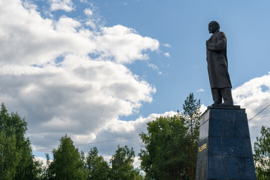 Lenin monument beside trees beneath an open summer sky in Ukhta, Komi Republic