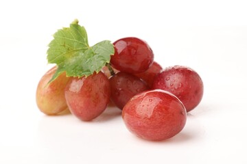 Fototapeta premium Fresh ripe grapes with green leaf on white background