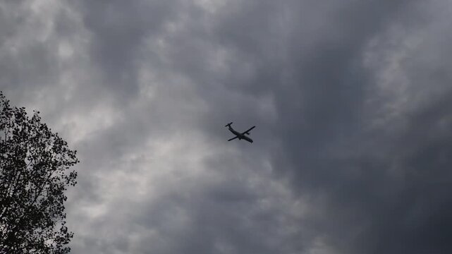 The airplane is flying through a cloudy sky